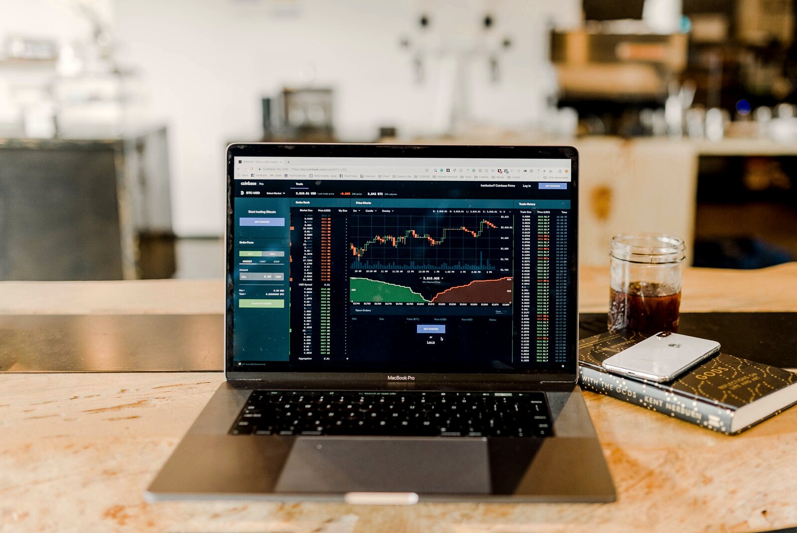 Laptop showing market charts on a wooden desk