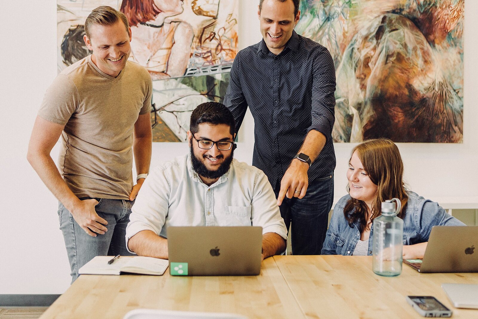 Start-up team gathered around a laptop